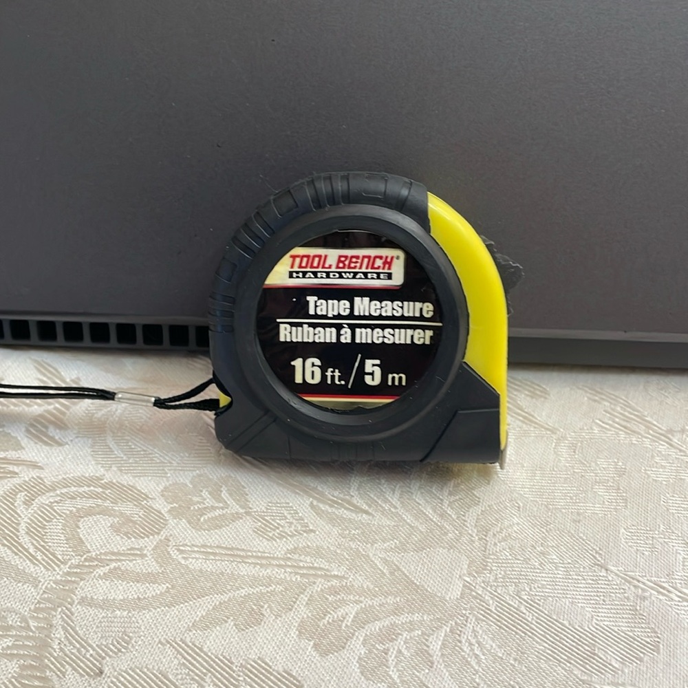 Preowned metal tape measurer that extends up to 16 feet.